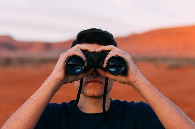 man looking with binoculars
