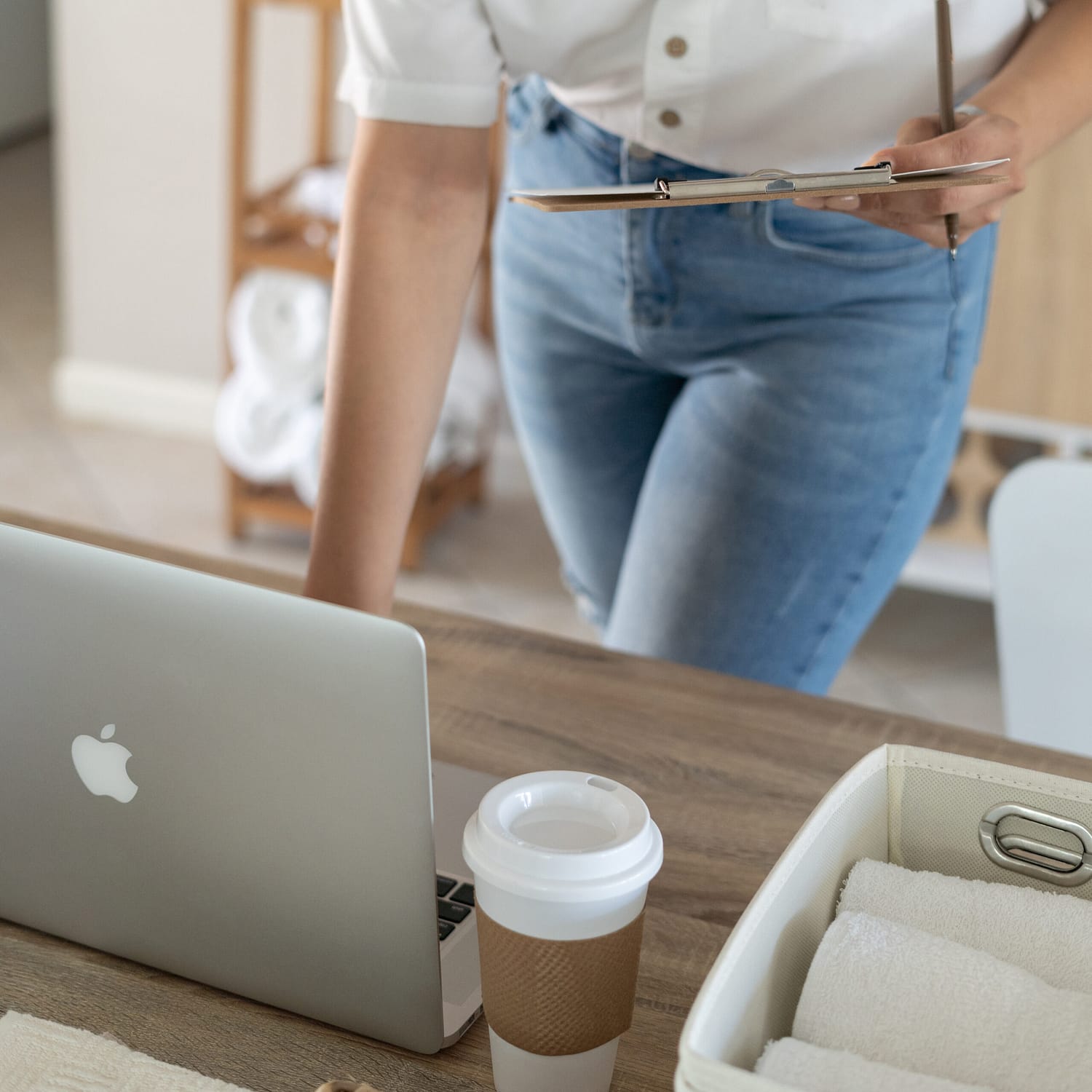 open laptop on desk with lady in jeans using keyboard