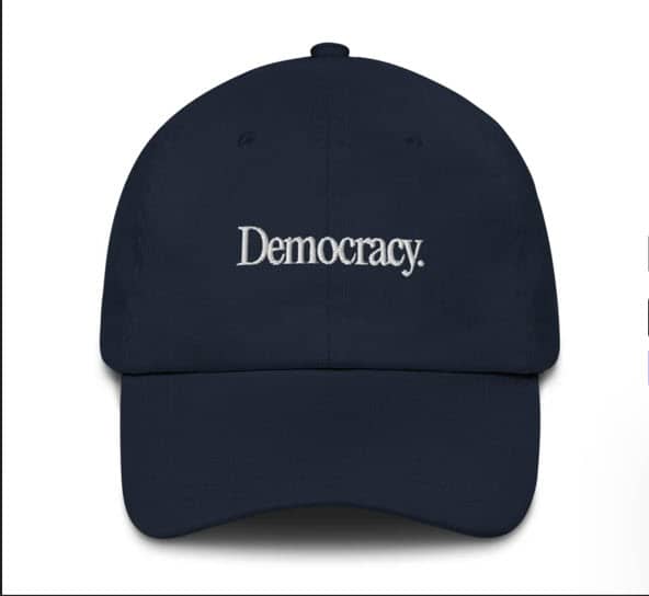 dark blue hat with the word DEMOCRAY in bold letters